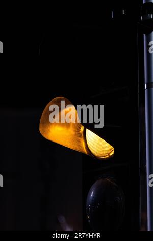 Eine Nahaufnahme einer hellgelben Straßenlaterne bei Nacht Stockfoto