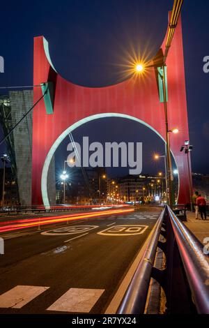 Bilbao, Spanien - 15. April 2022: Verkehr auf der La Salve Brücke mit Daniel Buren Skulptur, Arcos Rojos in Bilbao, bei Nacht mit Lichterbahnen Stockfoto