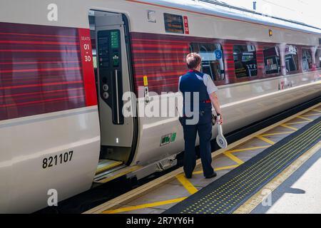 Bahnhof Grantham – Eine Zugführerin oder Wache, die einen London North Eastern (LNER) Azuma Train vom Bahnsteig aus absetzt Stockfoto