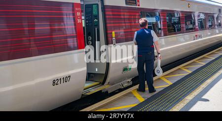 Bahnhof Grantham – Eine Zugführerin oder Wache, die einen London North Eastern (LNER) Azuma Train vom Bahnsteig aus absetzt Stockfoto