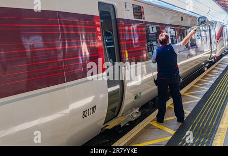 Bahnhof Grantham – Eine Zugführerin oder Wache, die einen London North Eastern (LNER) Azuma Train vom Bahnsteig aus absetzt Stockfoto