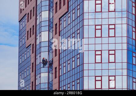 Die Arbeit als Fensterreiniger erfordert viel Anstrengung und Geschick, um das Glas glänzend sauber zu halten, insbesondere beim Reinigen von Hochhäusern im Stockfoto