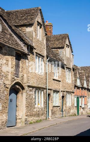 Sehen Sie die Church Street, typische Cotswold-Steinhäuser aus dem 15. Jahrhundert - 18. Jahrhundert im malerischen Cotswold-Dorf Lacock. Blauer Himmel. Stockfoto