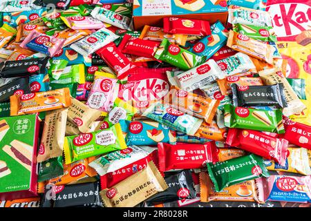 Bunte Auswahl verschiedener Gefälligkeiten japanischer Mini-zwei-Bar-Kit-Kats in einem kleinen Stapel, der von Rand zu Rand des Rahmens verläuft. Stockfoto