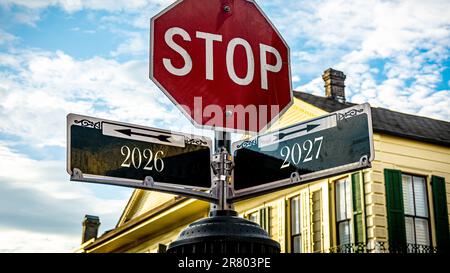 Ein Bild mit einem Hinweisschild, das in zwei verschiedene Richtungen auf Deutsch zeigt. Eine Richtung zeigt auf 2027, die andere auf 2026. Stockfoto