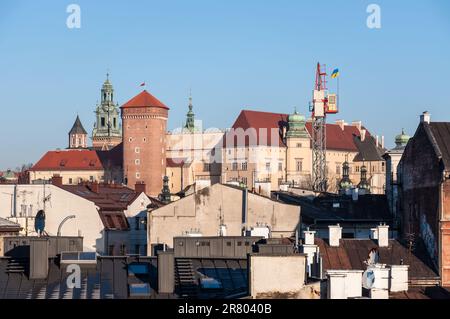 Krakau, Polen - 11. März 2022: Blick auf die Dächer der historischen Architektur der Stadt und das Wawelschloss im Hintergrund in Krakau, Polen Stockfoto