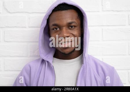 Portrait junger hübscher afrikanischer schwarzer Mann, der Jeansjacke an Backstein trägt und im Freien eine Wand mit Copyspace hat. Stockfoto