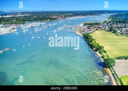 Segelboote und Yachten vor Anker und auf Pontons auf dem Fluss Hamble in Hampshire, England. Stockfoto