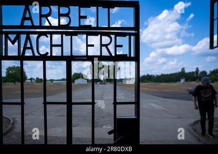 Oranienburg, Deutschland. 18. Juni 2023. Am Eingang zum ehemaligen KZ Sachsenhausen steht "Arbeit macht frei". Im Juni 1938 haben Kriminalpolizisten mehr als 10.000 Menschen in Konzentrationslager deportiert, wo sie mit einem schwarzen Winkel markiert waren. Die landesweite Verhaftungskampagne richtete sich gegen Personen, die von den Nationalsozialisten als "asozial" bezeichnet wurden. Unter ihnen waren Obdachlose, Alkoholiker und Leute mit Vorstrafen, die unter anderem bettelten. Kredit: Monika Skolimowska/dpa/Alamy Live News Stockfoto