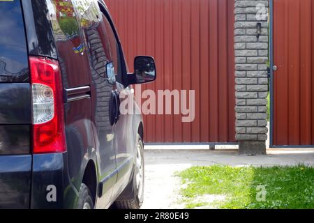 Ein gelbes Schild für Behinderte auf dem Glas eines Autos, das die Zugänglichkeit für Menschen mit Behinderungen anzeigt. Die Szene erfasst den Akt der Befestigung eines Stockfoto