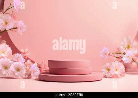 Rundes Podium mit rosafarbenem Zweig aus Sakura. Mockup zur Förderung ökologischer oder biologischer Produkte, Kosmetika. Stockfoto