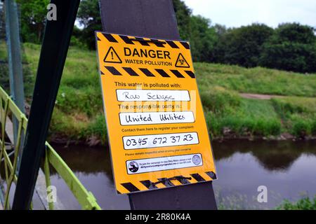 Manchester, Vereinigtes Königreich, 18. Juni 2023. In einer Protestmitteilung der Dirtywater-Kampagne auf der Jackson's Bridge über dem Fluss Mersey wird behauptet, dass der River Mersey, Sale Water Park, Großbritannien, durch rohes Abwasser verschmutzt ist, und behauptet, dass United Utilities (UU) dafür verantwortlich ist und eine Telefonnummer gibt, um eine Beschwerde einzureichen. Die Schmutzwasserkampagne scheint Teil der Rebellion zu sein, die ausgelöscht wurde. Im Februar berichtete die BBC, dass der nahe gelegene Stockport Council eine Untersuchung eingeleitet hatte, nachdem er festgestellt hatte, dass UU im Jahr 2022 977 Mal Abfall in den Fluss Mersey gebracht hatte. Kredit: Terry Waller/Alamy Live News Stockfoto