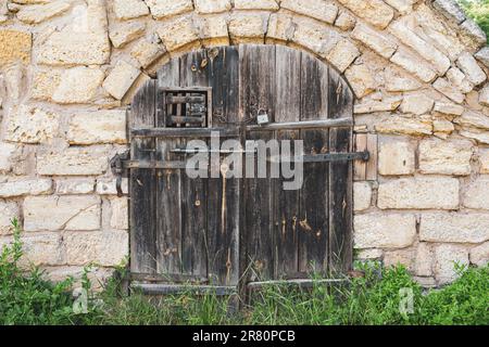 Wintage-Holztor in der Steinmauer Stockfoto