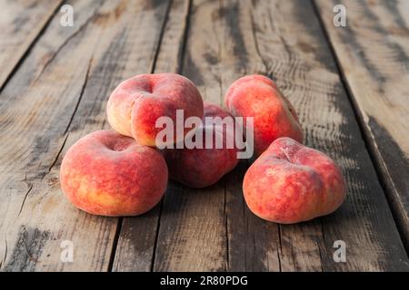 Reife, frische donat-Pfirsiche auf einem alten Holztisch Stockfoto