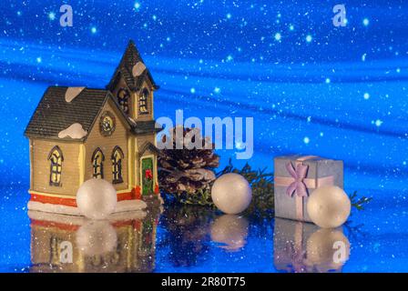 Wunderschöne kreative Winterkomposition. Weihnachtsgeschichte. Kleines Spielzeughaus. Magischer Hintergrund Stockfoto