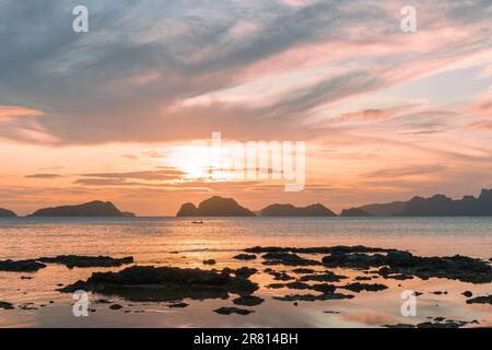 Unvergessliches Spektakel bei Sonnenuntergang am Strand Las Cabanas, El Nido, Palawan, den Philippinen Stockfoto