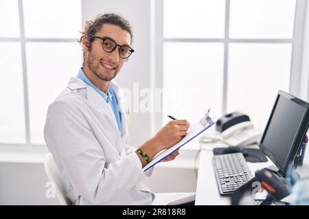 Junger hispanischer Apotheker, der auf einem Dokument in der Apotheke schreibt Stockfoto