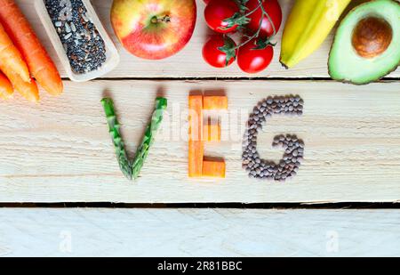 Farbenfrohes Obst, Gemüse, Holzhintergrund mit dem Wort „Gemüse“ Stockfoto