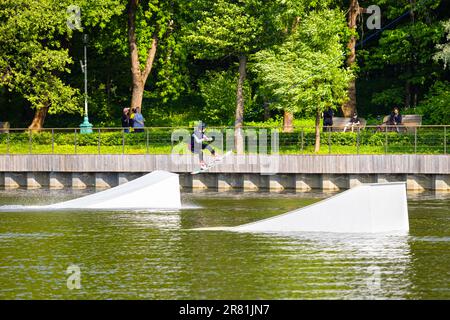 Moskau, Russland - 02. Juni 2023: Wakeboarden von Mädchen im Park. Ein Mädchen, das von einem Trampolin auf einem Wakeboard springt Stockfoto