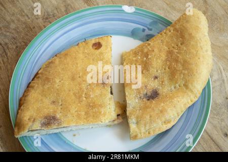 Weiße Pizza gefüllt mit spanischem Schinken, Pilzen und Streichkäse Stockfoto