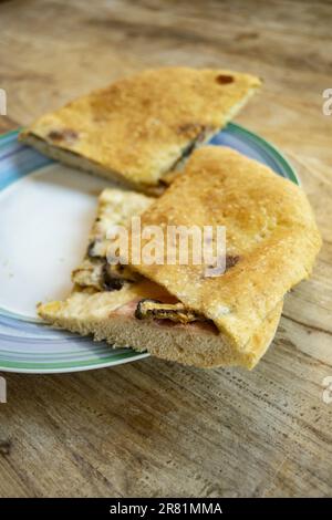 Weiße Pizza gefüllt mit spanischem Schinken, Pilzen und Streichkäse Stockfoto