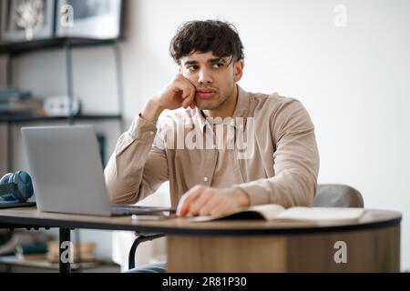 Verärgerter arabischer Geschäftsmann, der mit einem Laptop im Büro arbeitet Stockfoto
