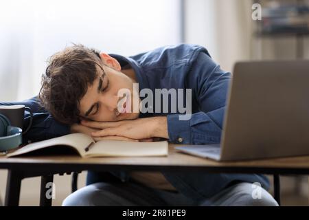 Arabischer Geschäftsmann In Der Nähe Eines Laptops, Der Eine Pause Für Ein Nickerchen Am Arbeitsplatz Macht Stockfoto