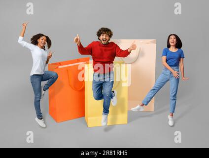 Multiethnische Leute, die sich mit riesigen Einkaufstaschen herumschlagen Stockfoto
