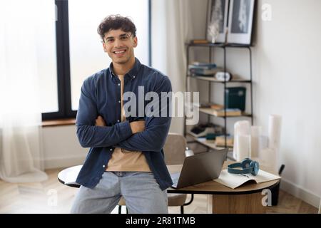 Selbstbewusster, lächelnder arabischer Geschäftsmann im Hemd, der im Amt steht Stockfoto