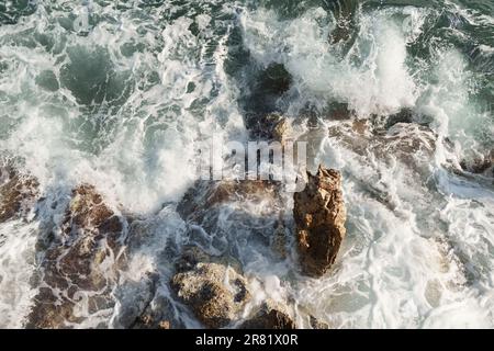 Fresnch Riviera Klippen mit Meereswellen, die auf ihnen brechen, Reiseinhalt Stockfoto