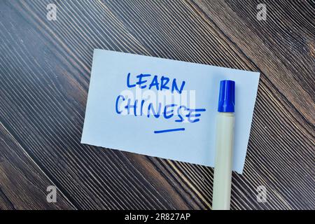 Konzept des chinesischen Lernens auf Haftnotizen isoliert auf einem Holztisch schreiben. Stockfoto