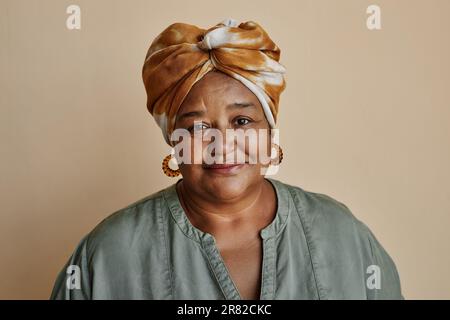 Taille hoch Porträt einer schwarzen Seniorin, die in die Kamera schaut und ein Kopftuch trägt Stockfoto