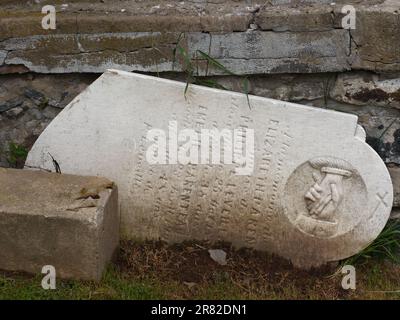 Ein alter, gebrochener Grabstein, der auf der Rückseite der katholischen Kirche Saint-Michel in Yamaska, Quebec, Kanada ruht Stockfoto