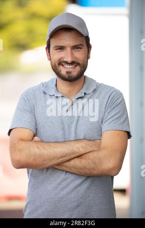 Porträt eines männlichen Arbeiters mit Gret Poloshirt und Mütze Stockfoto