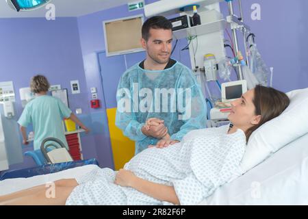 Wehengeburt im Krankenhaus mit Ehemann Stockfoto