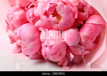 Strauß mit wunderschönen pinkfarbenen Pfingstrosen auf dem weißen Tisch, Nahaufnahme Stockfoto