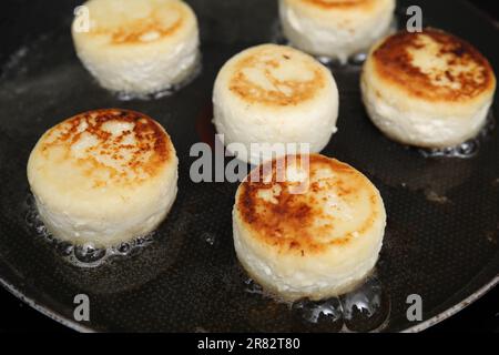 Leckere Pfannkuchen mit Hüttenkäse in der Pfanne, Nahaufnahme Stockfoto