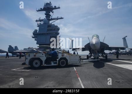 Aviation Boatswain's Mate (Handling) Airman Bruce Lee aus Spring Hill, Florida, dem worldÕs größten Flugzeugträger USS Gerald R. FordÕs (CVN 78) Air Department zugeteilt, schleppt einen F/A-18E Super Hornet, der an den „Tomcatters“ des Streikkampfgeschwaders (VFA) 31 befestigt ist, mit einem Flugzeugtraktor auf dem Cockett; 16. Juni 2023. VFA 31 wird an Bord von CVN 78 als Teil von Carrier Air Wing (CVW) 8 eingesetzt. Gerald R. Ford ist die USA Der neueste und fortschrittlichste Flugzeugträger, NavyÕs einen Generationssprung in den USA darstellt NavyÕs Fähigkeit, Energie auf globaler Ebene zu projizieren. Der Gerald R. Ford Carr Stockfoto