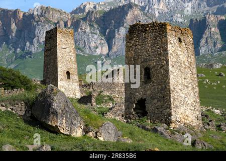 Zwei antike ossetische Verteidigungstürme vor der Kulisse des Kaukasus an einem sonnigen Junitag. Nordossetien, Alania. Russland Stockfoto