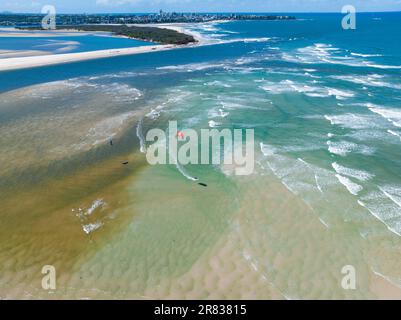 Luftaufnahme des Parasailing über Wellen in der Nähe einer Küstenstraße am Golden Beach an der Sunshine Coast von Queensland, Australien Stockfoto