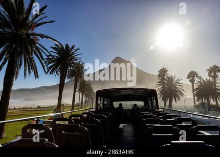 Blick vom Hop-on-Hop-off-Red Bus auf der Victoria Road in Camps Bay mit dem Lion's Head Mountain im Hintergrund - Kapstadt, Südafrika Stockfoto