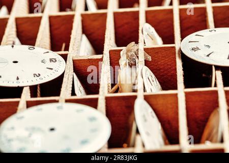 In einer Steampunk-Umgebung veranschaulicht ein Handwerkertisch mit Uhren, Zahnrädern und Federn die präzise mechanische Arbeit und die Verfeinerung der Horologie als beides Stockfoto