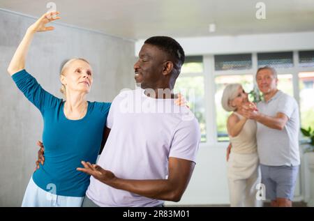 Gruppe multiethnischer Erwachsener, die Gesellschaftstanz tanzt Stockfoto