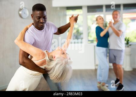 Gruppe multiethnischer Erwachsener, die Gesellschaftstanz tanzt Stockfoto