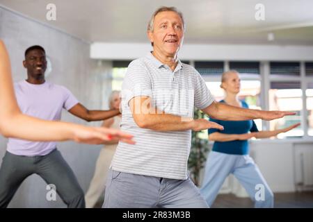 Älterer Mann, der im Gruppentanzkurs Hip-Hop praktiziert Stockfoto