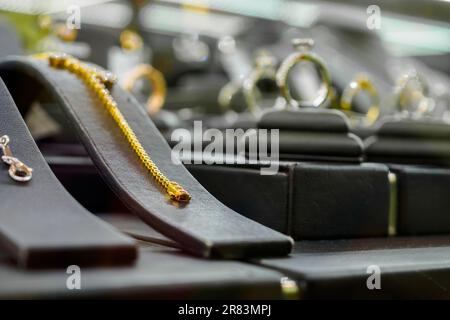 Goldschmuck-Diamantenladen mit Armbanduhren und Halsketten in einem luxuriösen Schaufenster Stockfoto