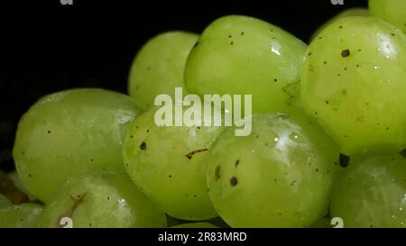Ein Haufen grüner Trauben mit Wassertropfen. Nahaufnahme Stockfoto