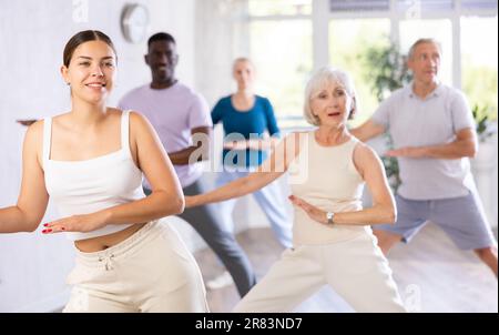 Eine Lehrerin unterrichtet ältere Schüler des Tanzkurses über grundlegende Bewegungen des Hip-Hop-Tanzes Stockfoto