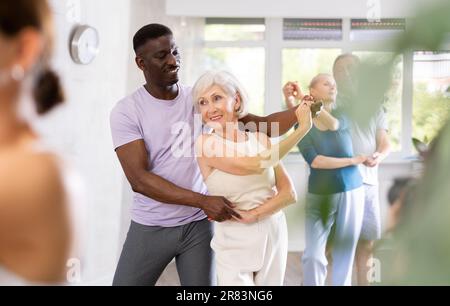 Gruppe multiethnischer Erwachsener, die Gesellschaftstanz tanzt Stockfoto