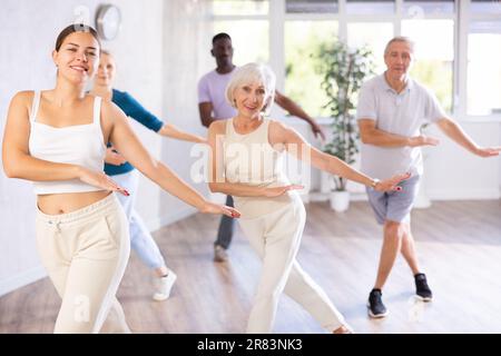 Eine Lehrerin unterrichtet ältere Schüler des Tanzkurses über grundlegende Bewegungen des Hip-Hop-Tanzes Stockfoto